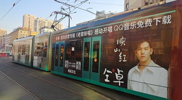 仝卓有轨电车应援现身大连 巨幅海报全包车身十分亮眼