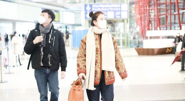 袁咏仪和张智霖现身机场，袁咏仪穿印花外套搭配白围巾，依旧很美