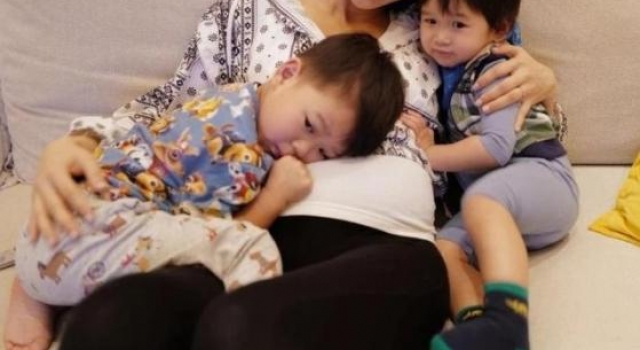 胡杏儿挺7月孕肚抱俩娃，大儿子趴在肚子上，小儿子乖巧紧靠怀中
